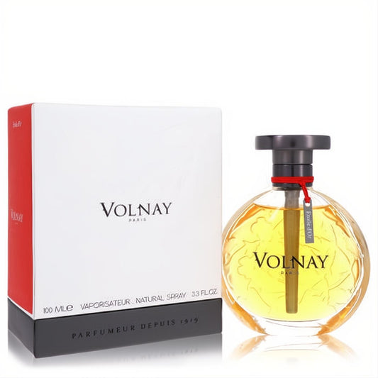 Exquisite Volnay Etoile D'or 3.3 oz EDP. Round glass bottle with golden liquid, embossed floral design, dark cap, and elegant white & black box.