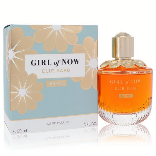 Elie Saab Girl of Now Shine 3 oz Eau De Parfum. Radiant orange liquid in a clear bottle with a gold floral cap, next to its elegant blue and gold box.