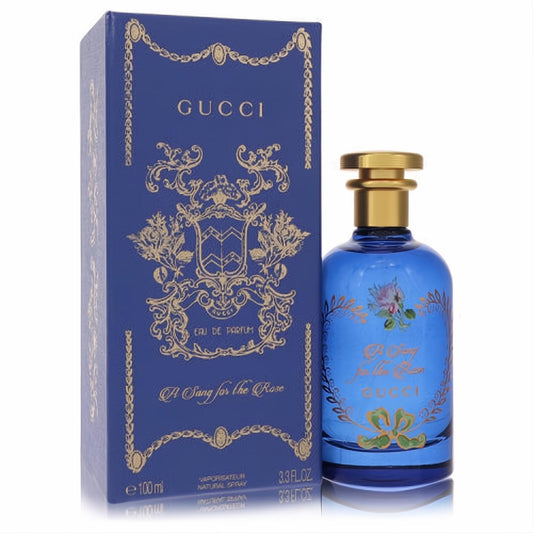 Gucci A Song for the Rose 3.3 oz EDP. Elegant blue glass bottle with gold cap and ornate floral details, next to its luxurious matching box.
