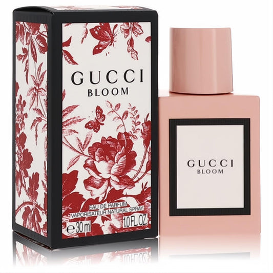 Experience Gucci Bloom 1 oz Eau De Parfum spray: elegant pale pink bottle, bold black box with red floral design.