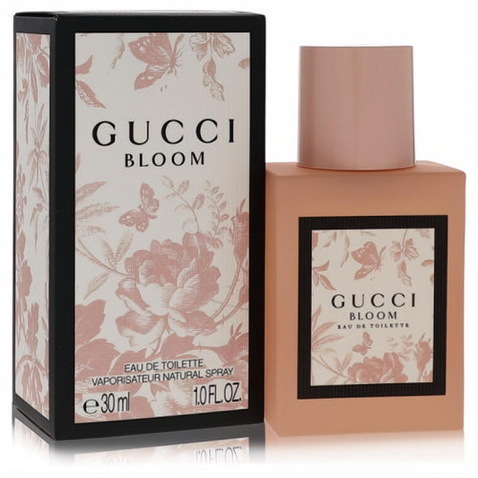 Gucci Bloom 1 oz Eau De Toilette: elegant matte peach-pink square bottle, beautifully adorned with a floral and butterfly patterned box.