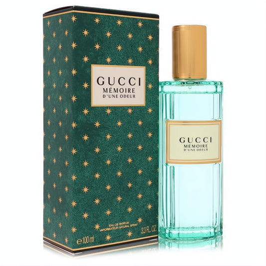 Gucci Memoire D'une Odeur 3.3 oz unisex EDP. Elegant ribbed teal glass bottle with gold cap and iconic dark green star box.