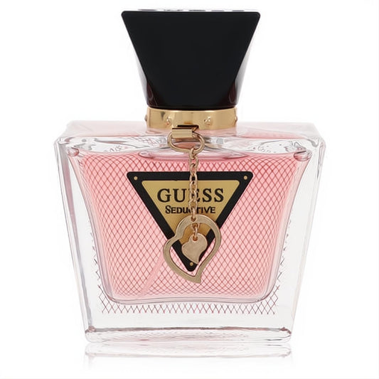 Guess Seductive I'm Yours 1.7 oz EDT. Pink fragrance in clear bottle with black cap, gold accents, mesh pattern, and heart charm.