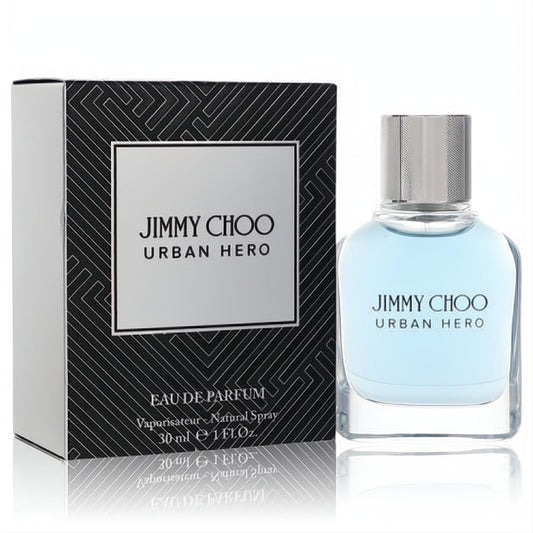 Jimmy Choo Urban Hero 1 oz Eau de Parfum spray. Sleek clear glass bottle with light blue fragrance and silver cap, next to a bold black patterned box.