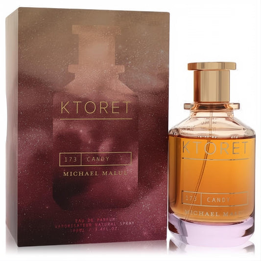 Luxurious Ktoret 173 Candy by Michael Malul 3.4 oz Eau De Parfum. Amber liquid in a clear bottle with gold cap, beside its gradient box.