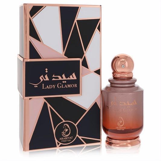 Glamorous Lady Glamor Arabiyat Prestige EDP. Rose gold ombre bottle with ornate crystal cap, next to a chic geometric black and rose gold box.