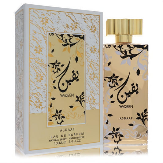 Exquisite Lattafa Asdaaf Yaqeen unisex EDP, 3.4 oz. Gold bottle with elegant black/white floral pattern & ribbed gold cap.