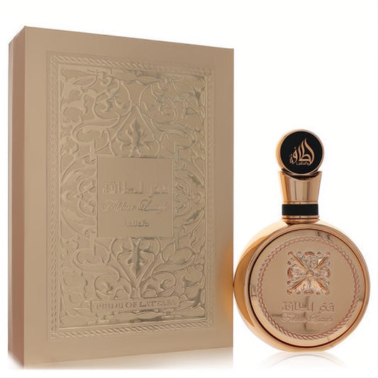 Luxurious Lattafa Fakhar Gold perfume. Round rose gold bottle with intricate emblem, black cap, and matching ornate embossed box.