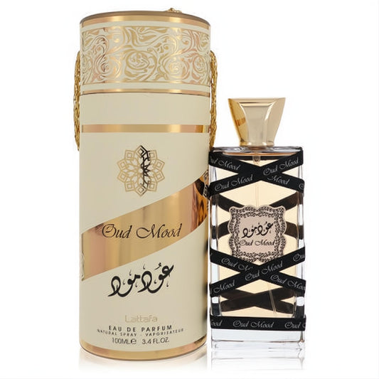 Experience Lattafa Oud Mood 3.4 oz unisex EDP. Exquisite clear bottle with gold cap, black ribbons, and luxurious cream & gold box.