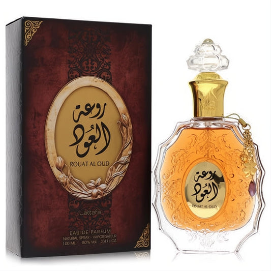 Captivating Lattafa Rouat Al Oud unisex EDP, 3.4 oz. Ornate clear glass bottle with amber liquid, gold accents, and a luxurious maroon box.