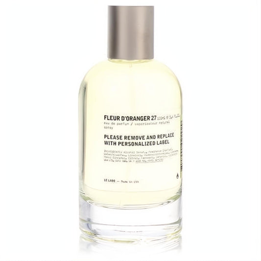 Elegant Le Labo Fleur D'oranger 27 Eau De Parfum spray. Clear glass bottle with light yellow fragrance and a sleek silver cap.