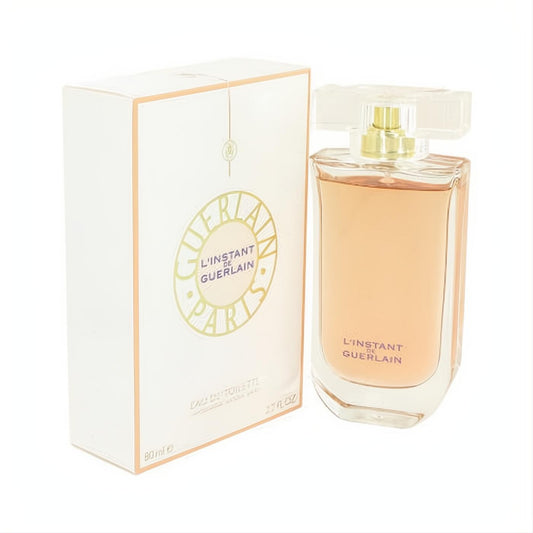 Luxurious L'instant de Guerlain Eau De Toilette 2.7 oz. Sleek clear glass bottle with amber liquid and elegant white box.