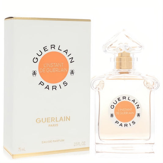Luxurious Guerlain L'instant 2.5 oz Eau De Parfum in a clear glass bottle with gold sprayer, featuring an orange and black label, beside its white box.