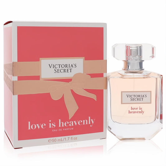 Victoria's Secret Love Is Heavenly 1.7 oz EDP. Elegant clear bottle with light peach fragrance, next to a beautiful coral gift box with a beige ribbon.