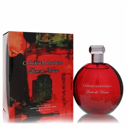 Discover Luxe De Venise 3.4 oz EDP: captivating deep red spherical bottle, sleek silver cap, and vibrant abstract art box.