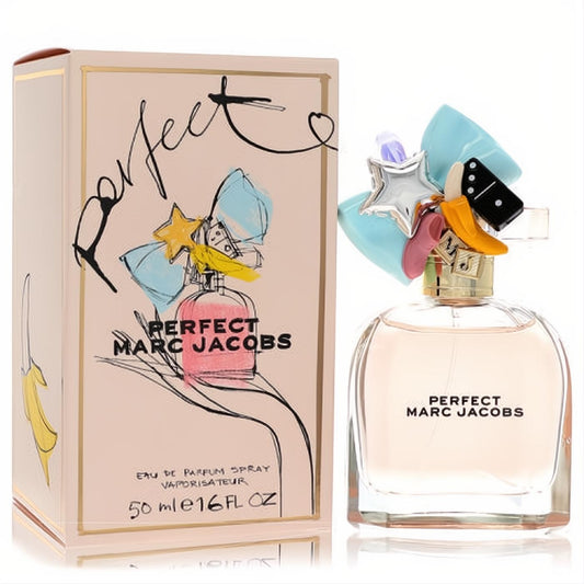 Marc Jacobs Perfect 1.6 oz EDP. Clear bottle with light pink liquid, topped by a whimsical cap adorned with colorful charms like a bow, star, and banana. Matching pink box.