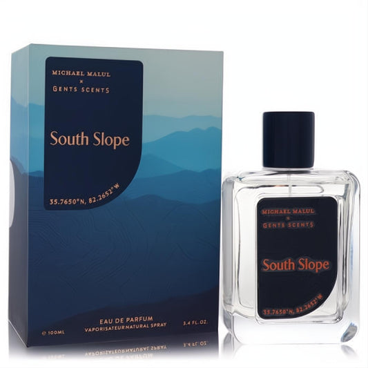 Michael Malul South Slope 3.4 oz Eau De Parfum. Clear glass bottle with dark label, alongside a striking blue mountain-themed box.