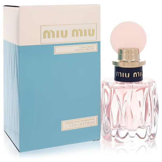 Miu Miu L'eau Rosee 1.7 oz EDT. Delicate pink faceted glass bottle with a chic pale pink cap, next to its elegant blue and beige box.