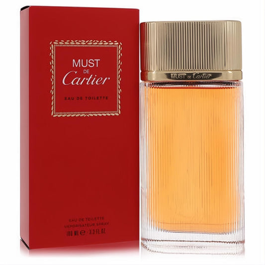 Must De Cartier 3.3 oz Eau De Toilette spray in a clear ribbed bottle with a luxurious gold cap, beside its elegant red and gold box.