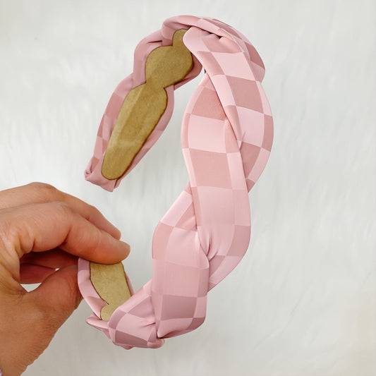 Elevate your style with this chic muted pink checkerboard twisted headband. Soft fabric, trendy design for comfortable wear.