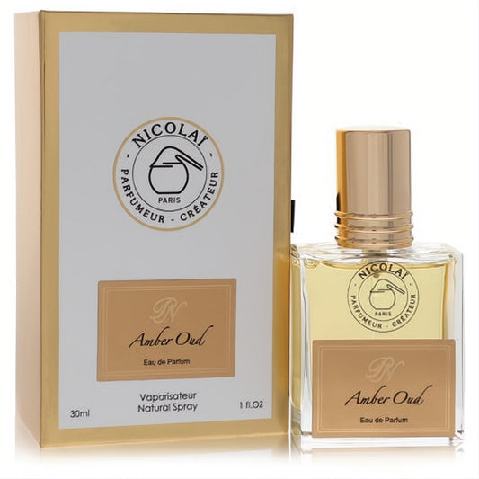 Nicolai Amber Oud 1 oz EDP spray in a clear glass bottle with amber liquid, gold cap, and elegant gold & white box.