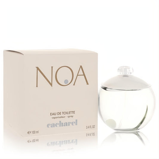 Noa by Cacharel 3.4 oz EDT spray. Elegant clear spherical bottle with white cap, signature pearl, and green accent, beside its beige box.