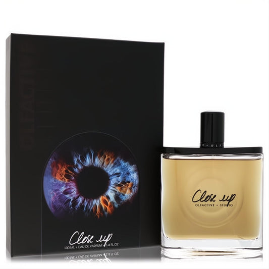 Olfactive Studio Close Up unisex EDP spray, 3.3 oz. Elegant clear bottle with amber liquid and a striking black box featuring a vibrant eye design.