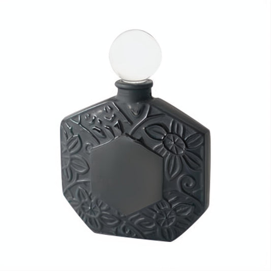 Elegant Ombre Rose perfume bottle: matte charcoal hexagonal design with intricate embossed floral patterns and a clear spherical stopper.