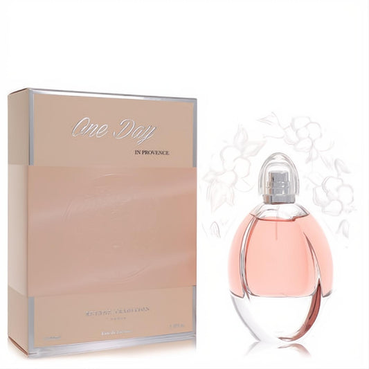 Elegant Reyane Tradition One Day in Provence 3.3 oz women's perfume. Pink liquid in clear glass bottle with silver cap, beside peach box.
