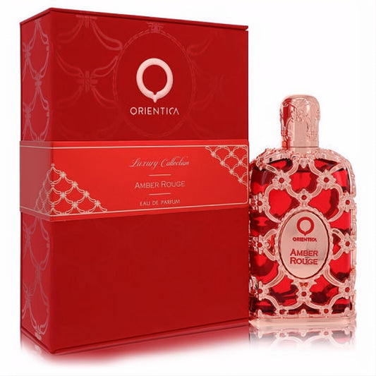 Captivating Orientica Amber Rouge 2.7 oz unisex perfume. Elegant red glass bottle with intricate gold filigree design and matching luxury box.