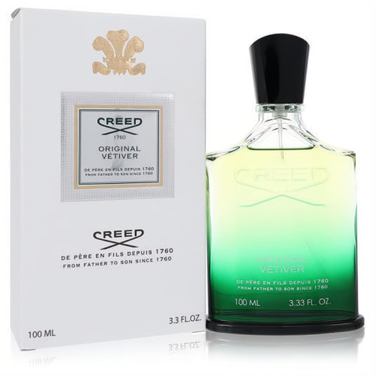 Experience luxury with Creed Original Vetiver 3.3 oz EDP. Sleek clear glass bottle with vibrant green-yellow liquid, beside its elegant white box.