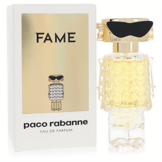 Paco Rabanne Fame 1 oz EDP spray. Daring robot bottle in gold and clear glass, with black sunglasses, beside its sleek white and gold box.