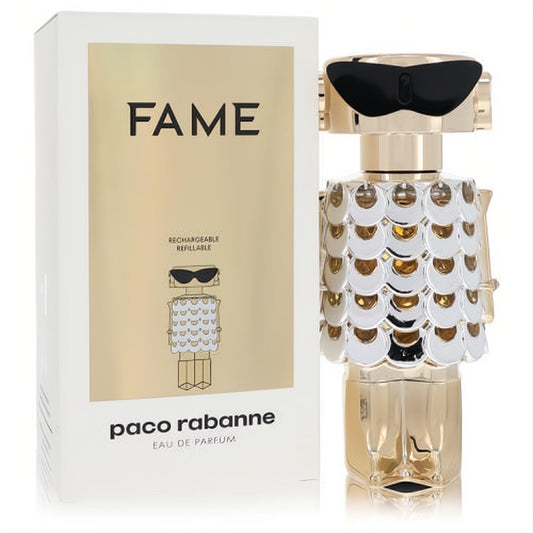 Dazzling Paco Rabanne Fame gold robot perfume bottle with white scale dress, chic sunglasses, and its stylish refillable packaging.