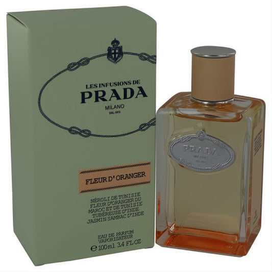 Prada Infusion De Fleur D'oranger 3.4 oz EDP. Clear glass bottle with warm amber liquid, elegant tan cap, and iconic sage green box.