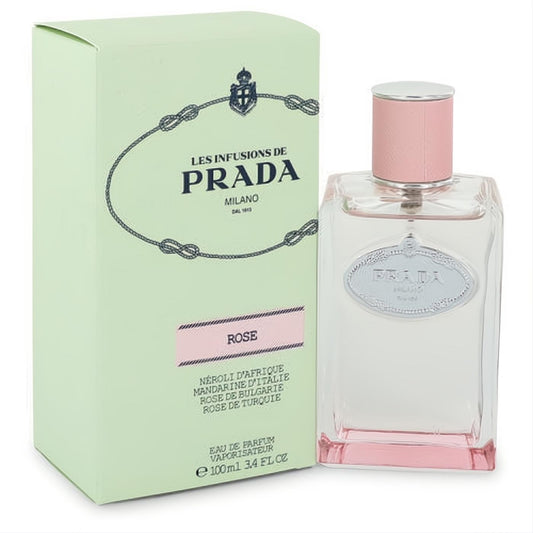 Prada Infusion De Rose 3.4 oz EDP: Elegant clear glass bottle with pink liquid, silver logo, and matching cap, next to its pale green box.