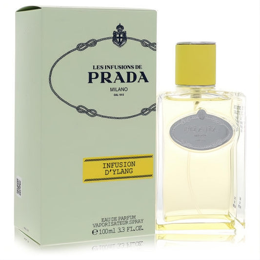 Prada Les Infusions D'Ylang 3.3 oz unisex EDP. Clear glass bottle with yellow cap and iconic silver label, beside a chic mint green box.