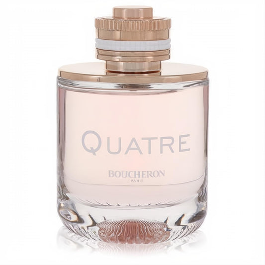 Elegant Boucheron Quatre women's perfume. Clear glass bottle, pale pink liquid, rose gold cap with white ring, and textured base.