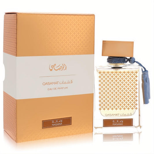 Luxurious Rasasi Qasamat Rasana 2.2 oz unisex EDP. Clear bottle with intricate gold pattern, brown cap, blue tassels, and matching gold box.