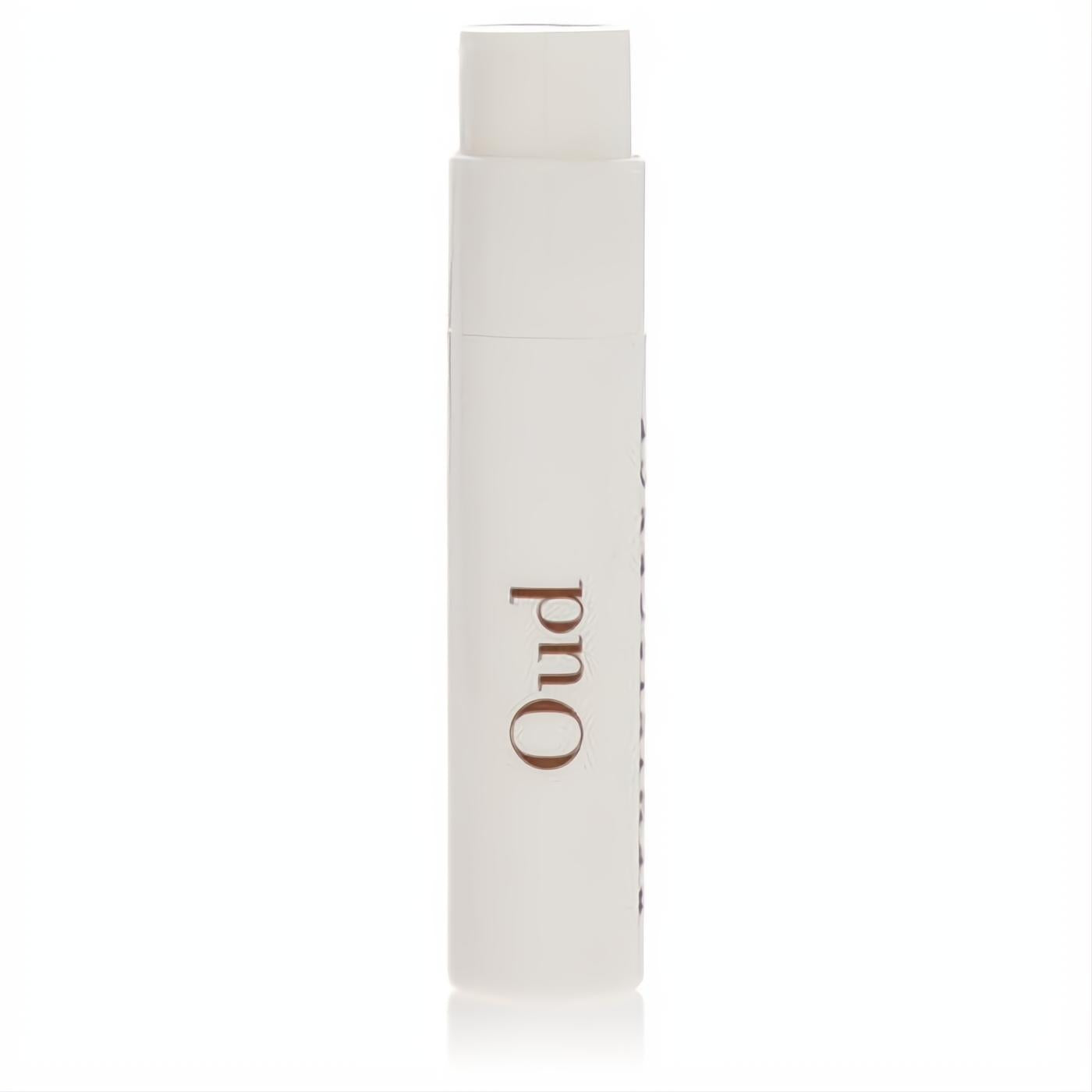 Elegant white Reminiscence Oud perfume sample vial, .04 oz, featuring "Oud" in rich brown. Experience luxury.