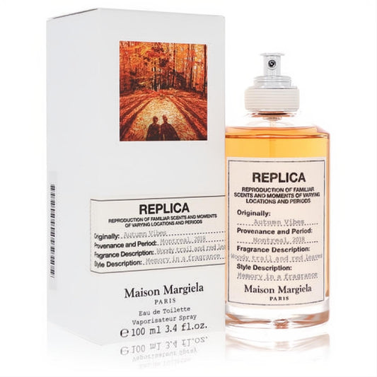 Maison Margiela Replica Autumn Vibes 3.4 oz EDT. Amber liquid in a sleek bottle with white label and matching autumn forest box.