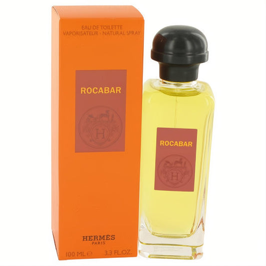 Luxurious Hermes Rocabar Eau De Toilette spray, 3.3 oz clear glass bottle with amber liquid and black cap, beside its iconic orange box.