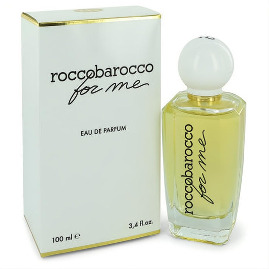 Elegant Roccobarocco For Me 3.4 oz Eau De Parfum. Clear glass bottle with light yellow liquid, white spherical cap, and matching white box with gold trim.