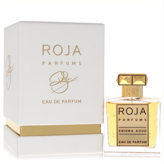 Discover Roja Enigma Aoud Eau De Parfum. Clear glass bottle with faceted gold cap, rich amber liquid, and elegant white & gold box.