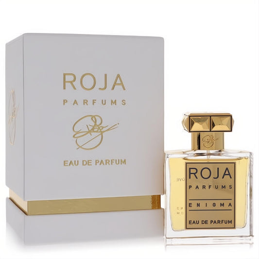 Luxurious Roja Enigma women's perfume. Clear glass bottle with gold label, cap, and amber liquid, beside its elegant white and gold box.