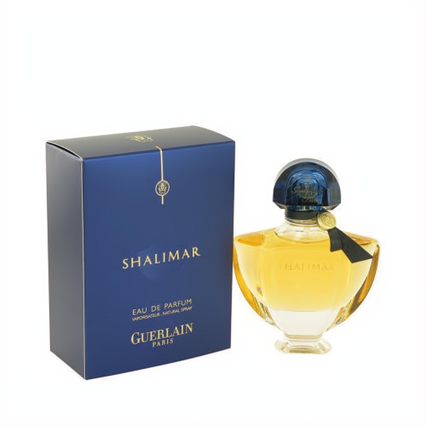 Luxurious Guerlain Shalimar 1 oz EDP. Amber liquid in a clear glass bottle with a blue cap and black ribbon, beside a navy gold-lettered box.