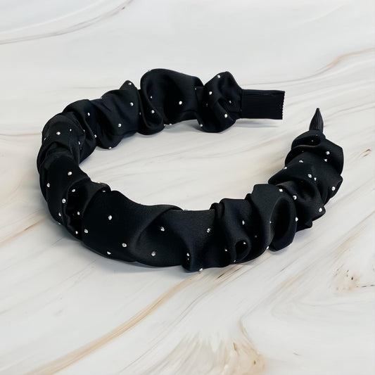 Black scrunched satin headband adorned with sparkling jewel dots. Elevate your look effortlessly.