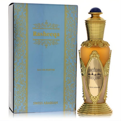 Swiss Arabian Rasheeqa 1.7 oz Eau de Parfum. Elegant amber and gold bottle with a blue gem cap, next to its ornate blue box.