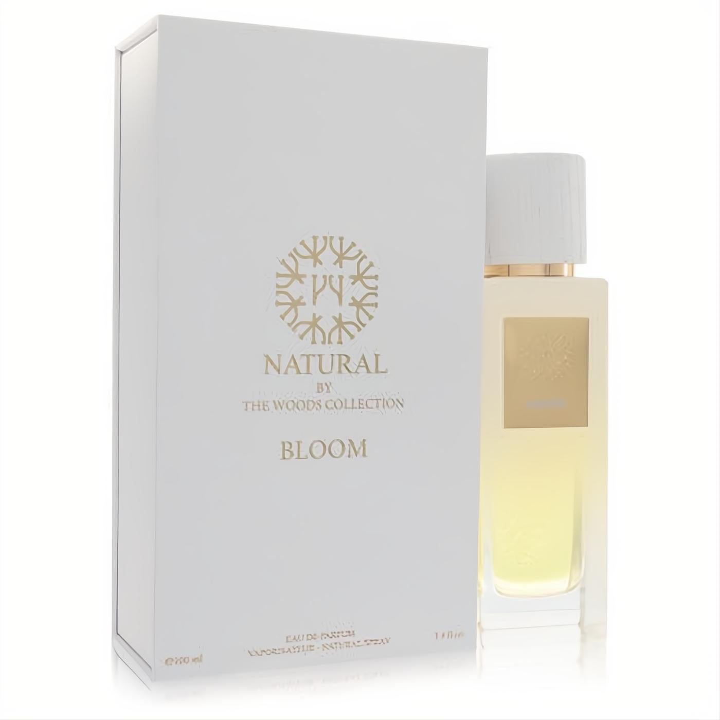 Elegant white box and clear glass bottle of Natural Bloom by The Woods Collection 3.4 oz unisex Eau De Parfum. Gold accents, wood-look cap.