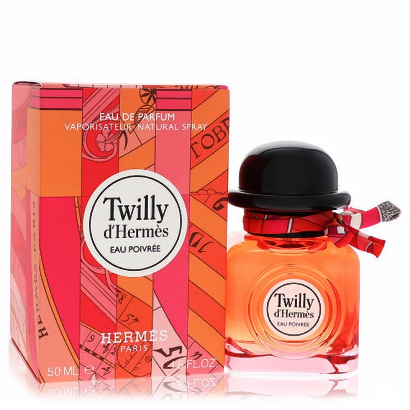 Twilly d'Hermès Eau Poivrée 1.7 oz perfume. Amber liquid in a chic bottle with black hat cap and signature ribbon, next to its vibrant red and orange box.