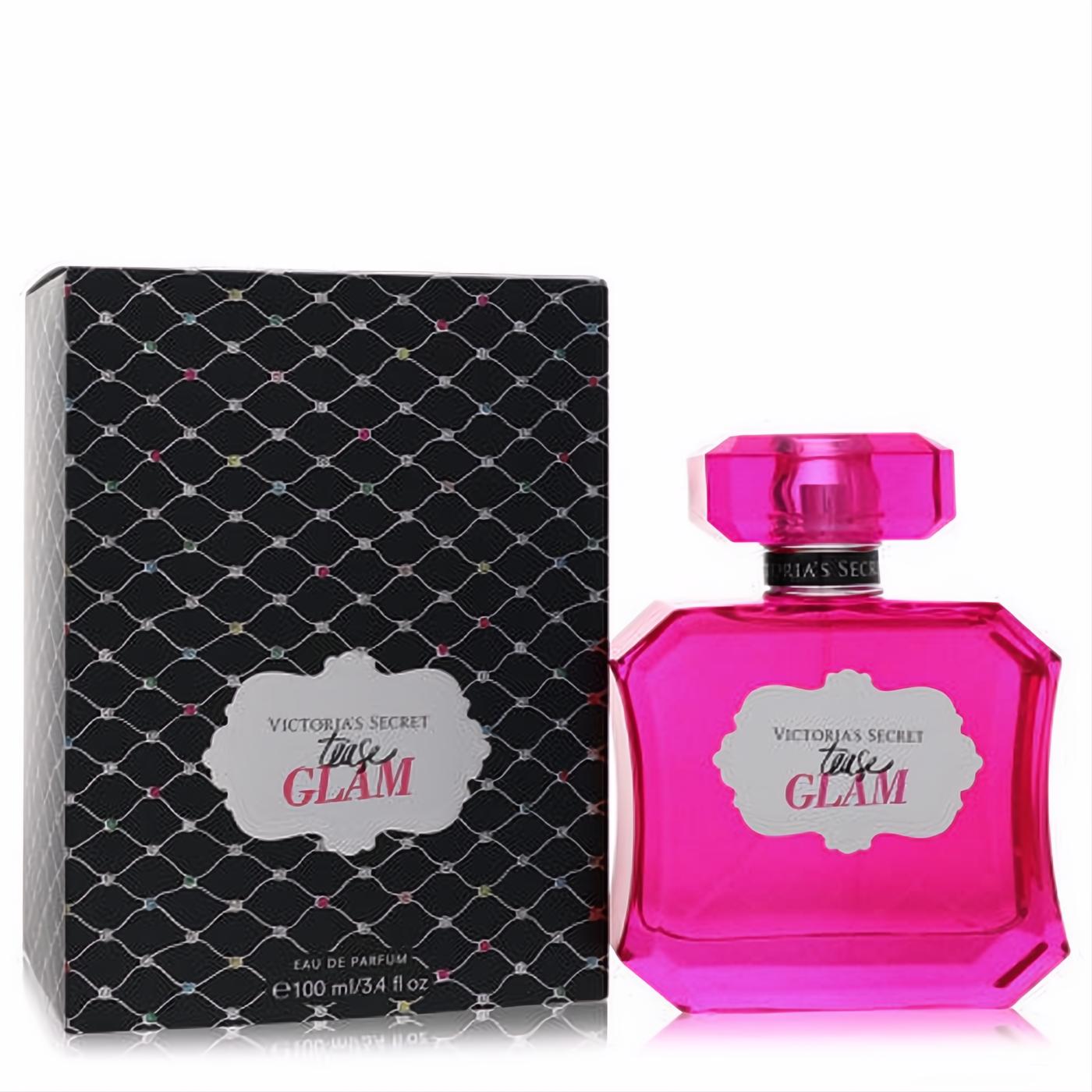 Victoria's Secret Tease Glam 3.4 oz EDP in a dazzling hot pink faceted bottle next to its elegant black patterned box.